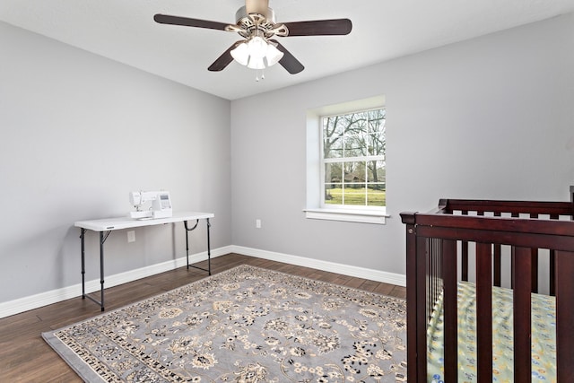 bedroom featuring dark wood-style floors, a ceiling fan, and baseboards