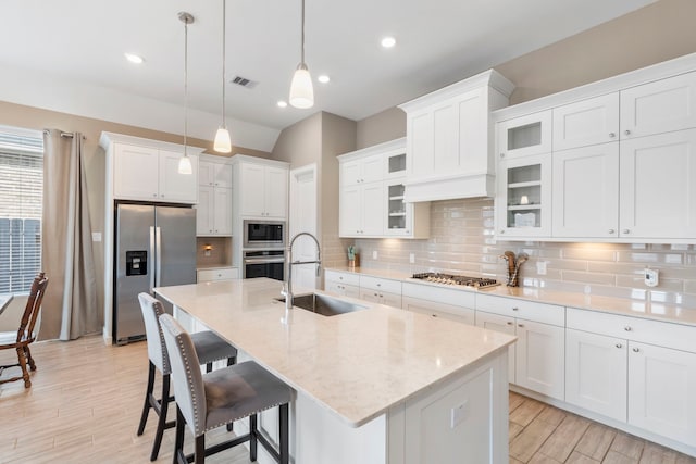 kitchen with a sink, stainless steel appliances, tasteful backsplash, and visible vents