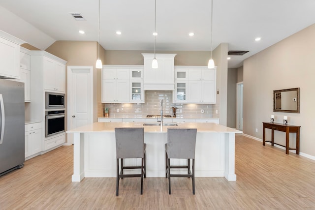 kitchen with light countertops, white cabinets, visible vents, and stainless steel appliances