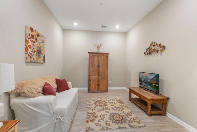 living room featuring wood finish floors, visible vents, baseboards, and recessed lighting