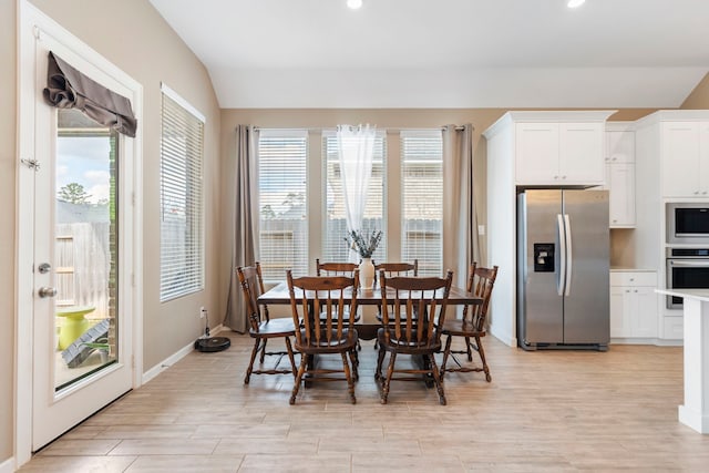 dining area with recessed lighting, light wood-type flooring, lofted ceiling, and baseboards