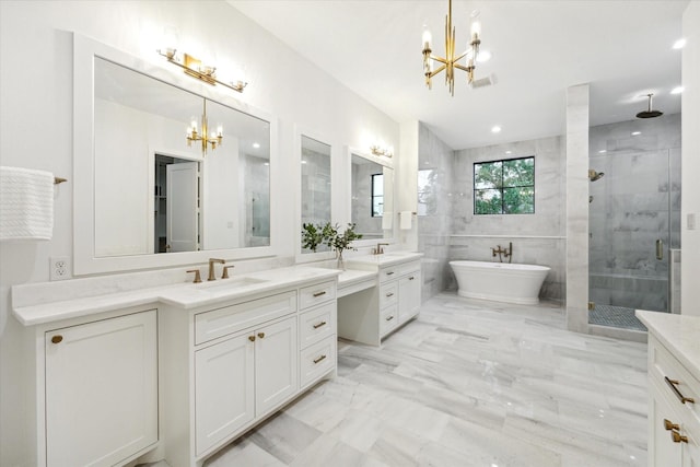 full bathroom featuring tile walls, two vanities, a stall shower, a sink, and a chandelier