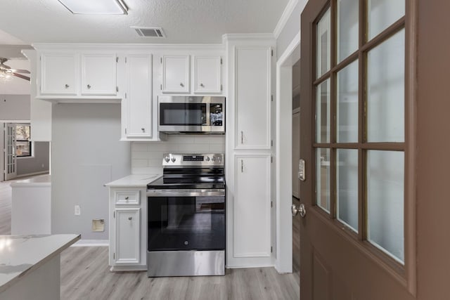 kitchen featuring white cabinets, light wood finished floors, stainless steel appliances, and a ceiling fan