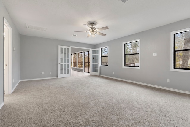 spare room with french doors, carpet, visible vents, and a healthy amount of sunlight