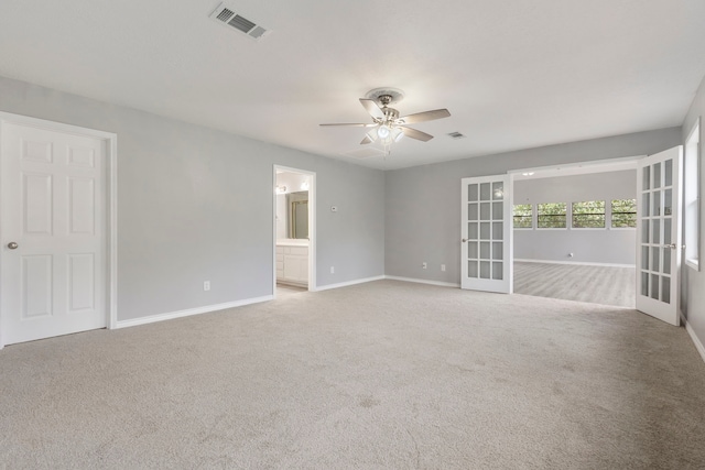 carpeted empty room featuring visible vents, french doors, a ceiling fan, and baseboards