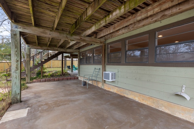 view of patio / terrace with a wall mounted air conditioner and stairway