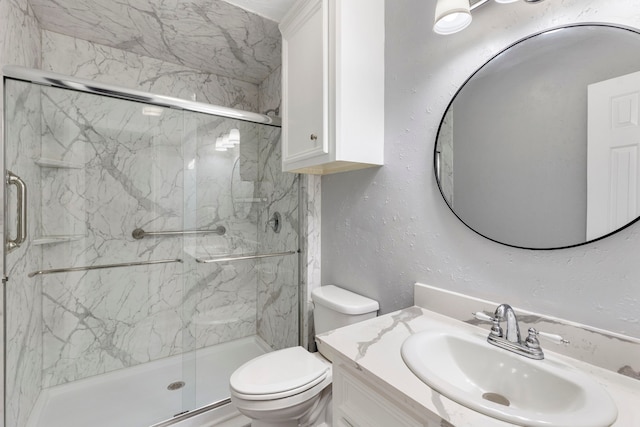 bathroom featuring a textured wall, toilet, vanity, and a marble finish shower