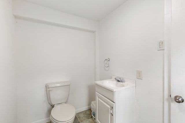 bathroom with baseboards, vanity, and toilet