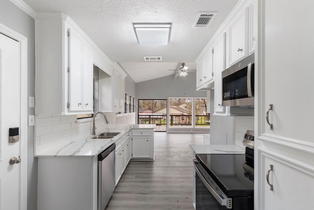 kitchen featuring appliances with stainless steel finishes, visible vents, a sink, and white cabinetry