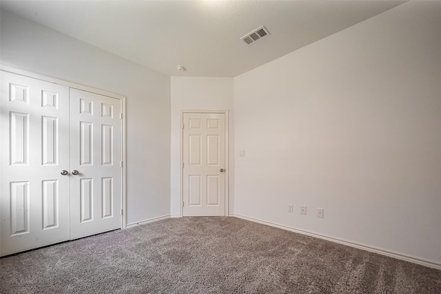 unfurnished bedroom featuring baseboards, a closet, visible vents, and carpet flooring