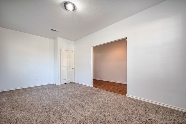 spare room featuring baseboards, visible vents, and carpet flooring