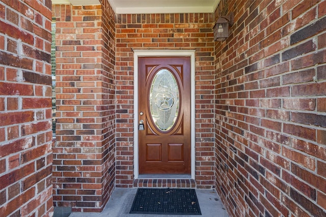 entrance to property featuring brick siding