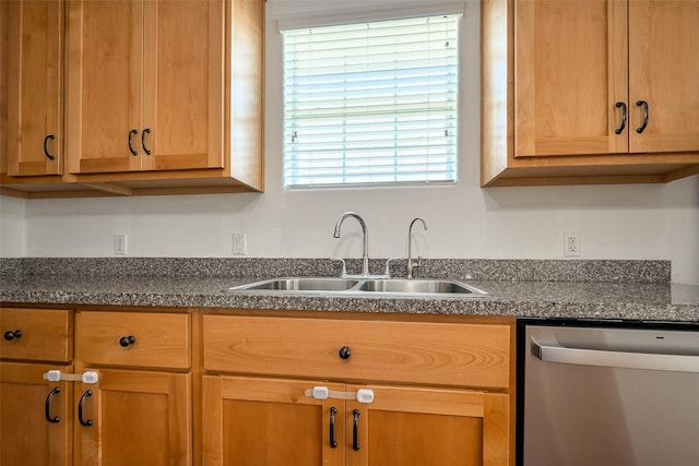 kitchen with a sink, dark countertops, and dishwasher