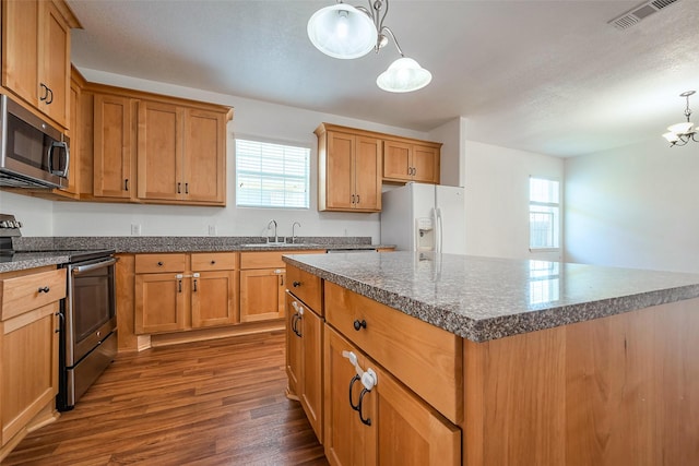 kitchen with dark wood-style flooring, a sink, visible vents, appliances with stainless steel finishes, and plenty of natural light