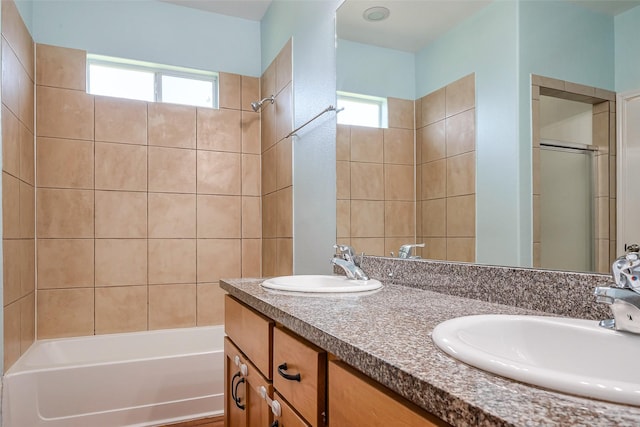 bathroom with double vanity, bathtub / shower combination, and a sink