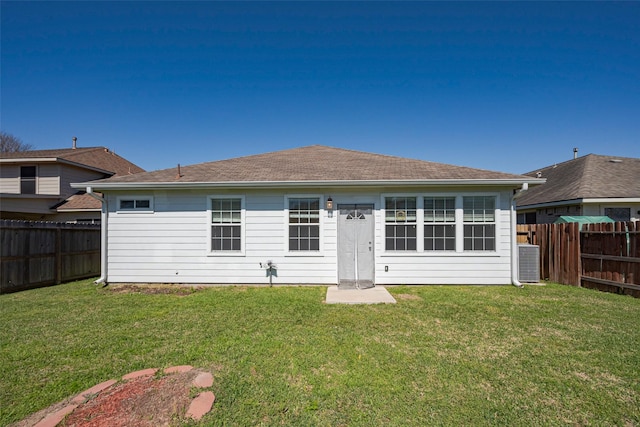 back of house with a fenced backyard, cooling unit, and a yard