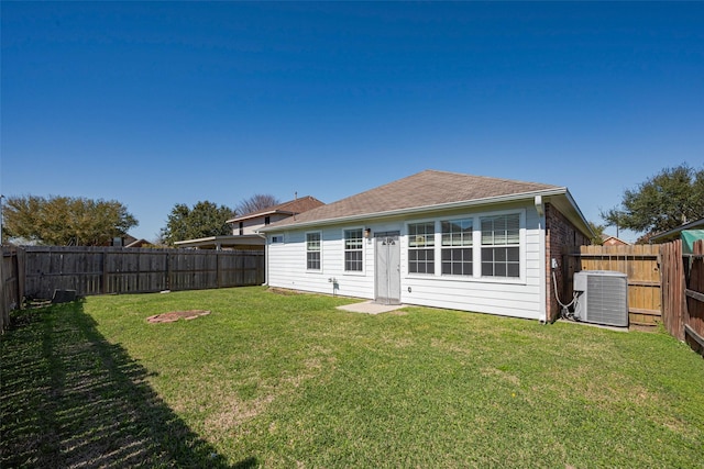 back of house featuring a yard, central AC unit, and a fenced backyard