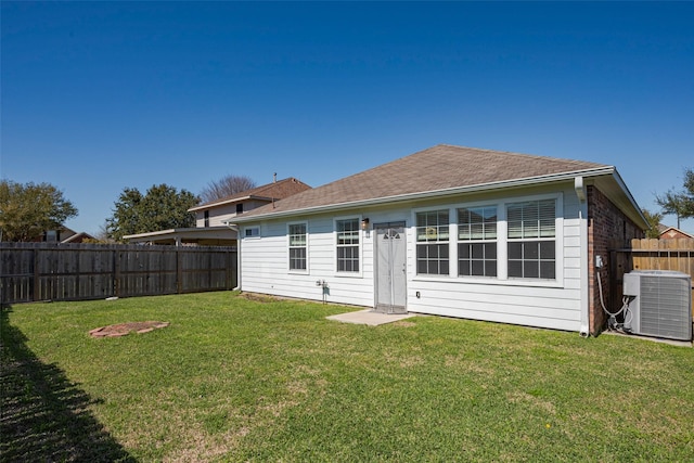 back of house with a yard, a shingled roof, a fenced backyard, and cooling unit