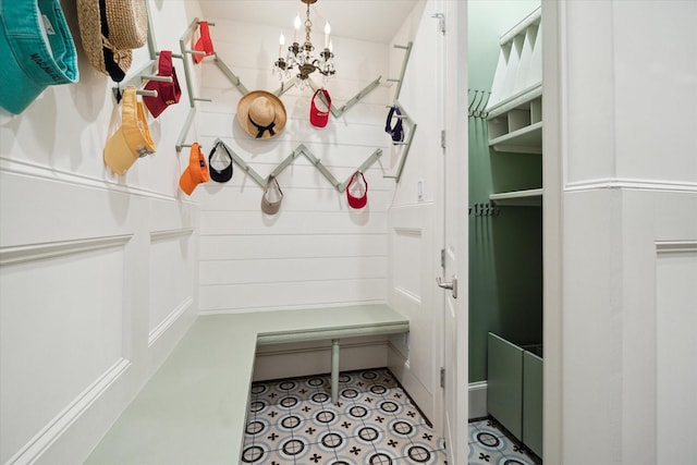 mudroom with tile patterned flooring and a notable chandelier