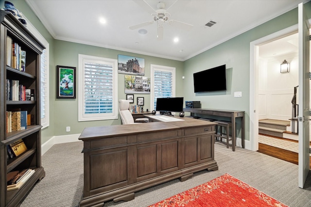 office space with visible vents, ornamental molding, a ceiling fan, light carpet, and baseboards