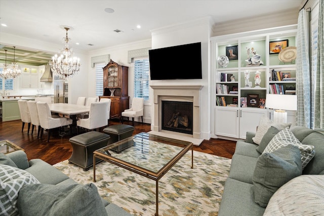 living room with crown molding, dark wood finished floors, a fireplace, a notable chandelier, and visible vents