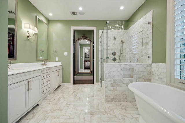 full bathroom featuring double vanity, a freestanding tub, a stall shower, and a sink