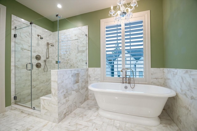 full bathroom featuring a wainscoted wall, marble finish floor, a freestanding tub, a shower stall, and tile walls