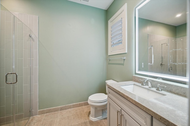 bathroom with baseboards, a shower stall, toilet, and vanity