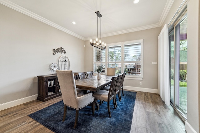 dining space with baseboards, wood finished floors, and crown molding