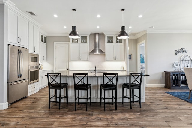 kitchen with visible vents, stainless steel appliances, white cabinets, crown molding, and wall chimney range hood