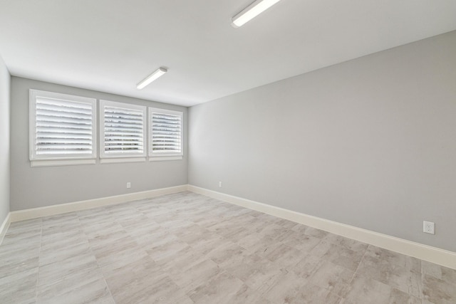 unfurnished room with baseboards