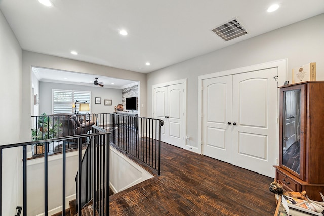 corridor with an upstairs landing, visible vents, recessed lighting, and dark wood-type flooring