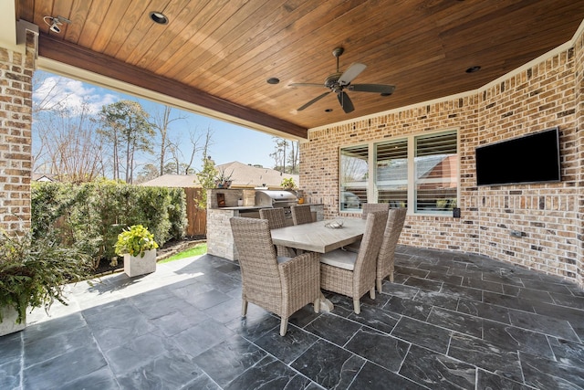 view of patio / terrace with fence, exterior kitchen, area for grilling, outdoor dining area, and ceiling fan