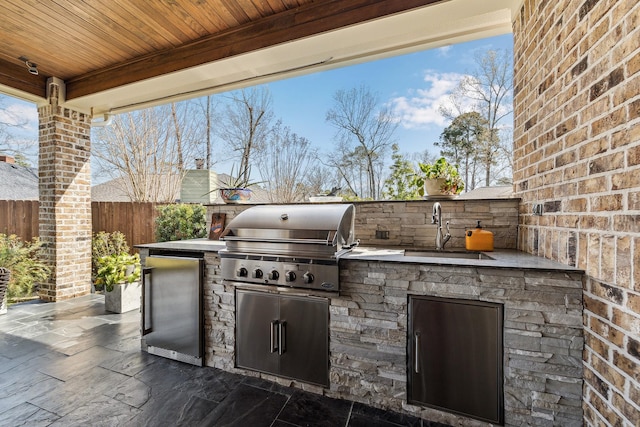 view of patio featuring a sink, area for grilling, a grill, and fence