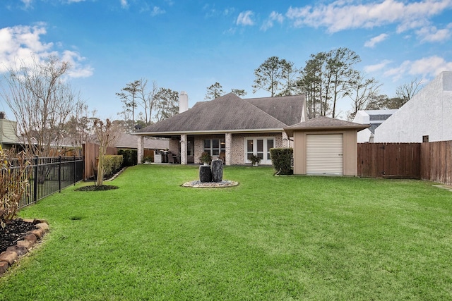 rear view of house featuring a lawn, a fenced backyard, and a chimney