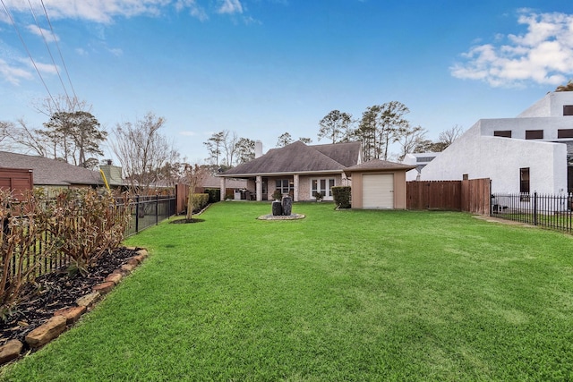 view of yard with an attached garage and a fenced backyard