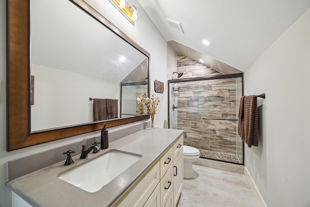 bathroom featuring toilet, a stall shower, vanity, and vaulted ceiling