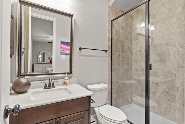 bathroom featuring toilet, a stall shower, and vanity