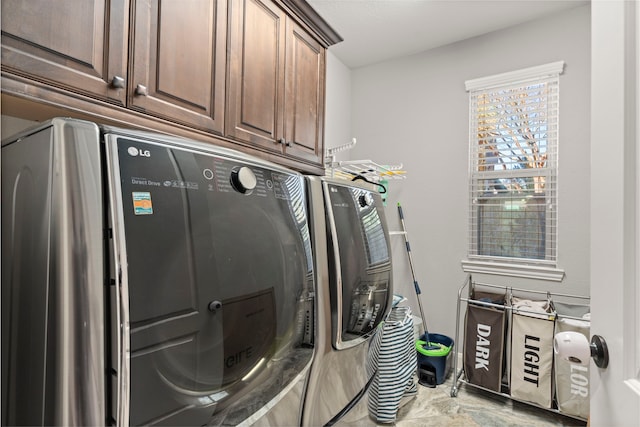 clothes washing area featuring cabinet space and independent washer and dryer