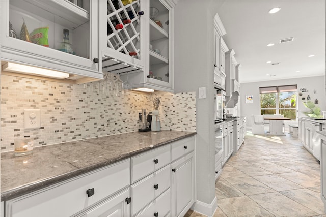 kitchen featuring white cabinetry, stainless steel oven, and backsplash