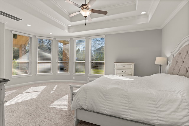 bedroom with carpet flooring, visible vents, baseboards, a raised ceiling, and crown molding