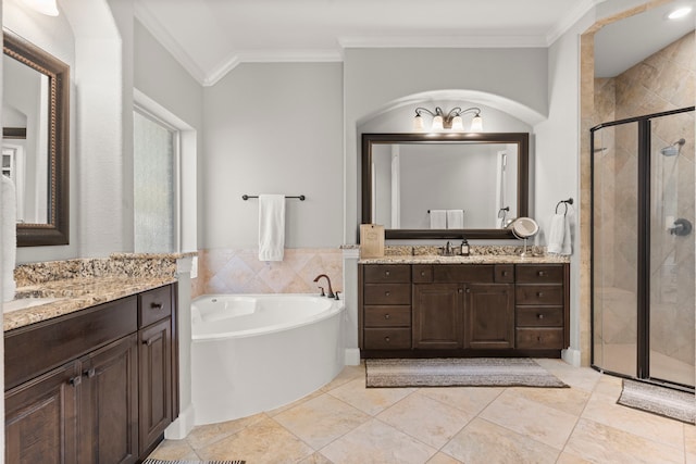 full bath with a bath, a shower stall, two vanities, and crown molding