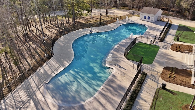 pool featuring a patio, an outdoor structure, and a fenced backyard