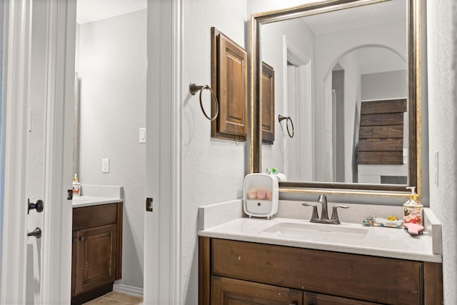 bathroom featuring a textured wall and vanity