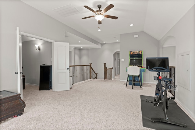 workout area featuring arched walkways, recessed lighting, baseboards, vaulted ceiling, and carpet