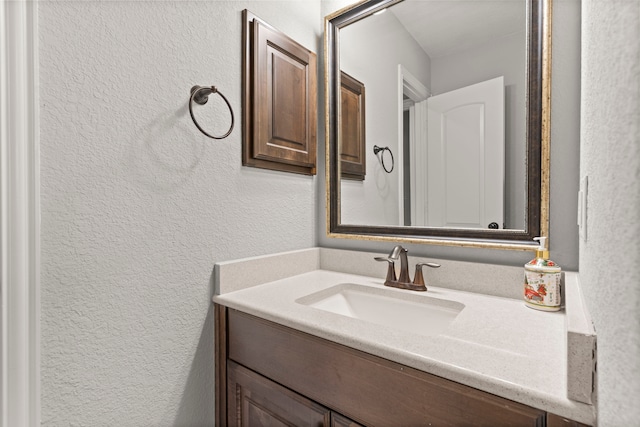 bathroom featuring a textured wall and vanity