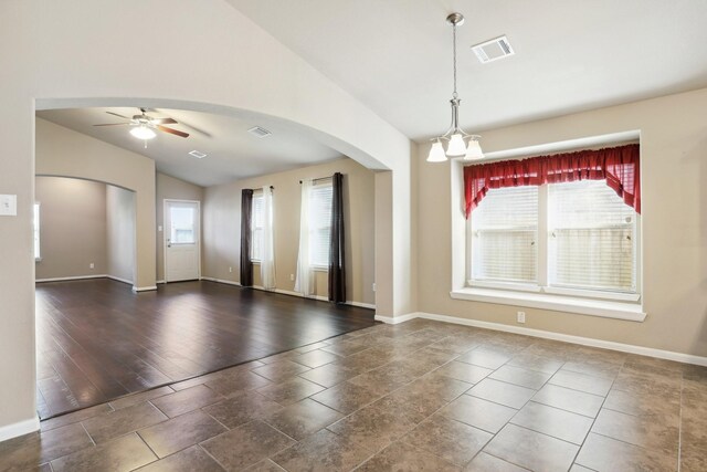 spare room with vaulted ceiling, visible vents, arched walkways, and a wealth of natural light