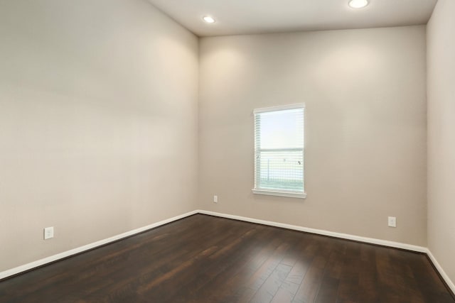 empty room with dark wood-style floors, recessed lighting, and baseboards