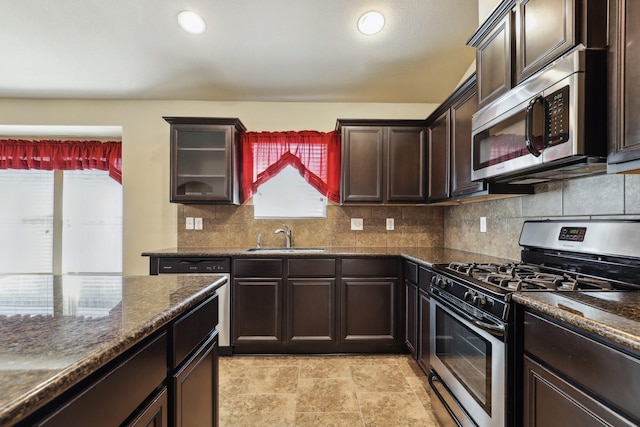 kitchen with recessed lighting, decorative backsplash, appliances with stainless steel finishes, dark brown cabinetry, and a sink