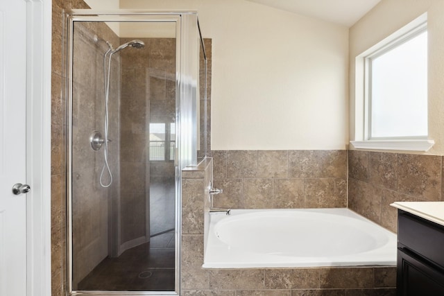 bathroom featuring a garden tub, a shower stall, and vanity